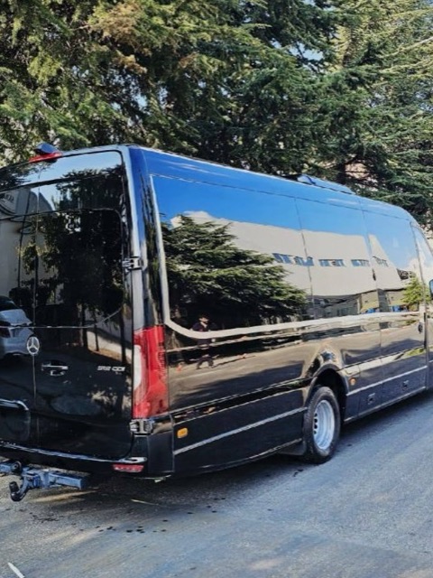 Vue de trois quarts arrière du minibus, avec les portes arrière, les feux et l'attelage