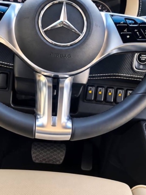 Volant gainé de cuir avec commandes multifonction, vu depuis le poste de conduite